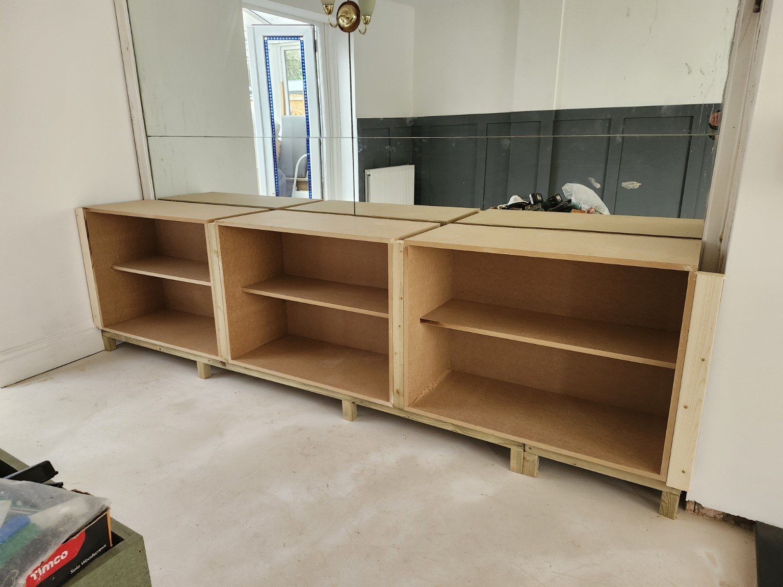 MDF base cabinet carcasses fitted beneath the existing mirror