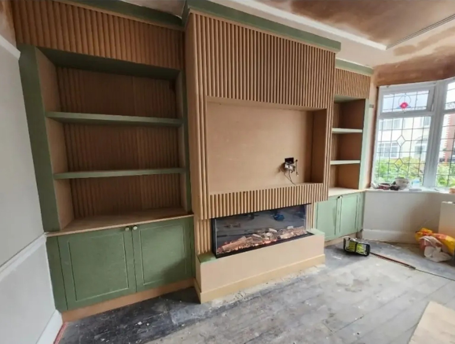 During the build: fitted alcove cupboards, shelves, fluted panelling, TV recess and electric fire